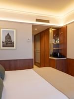 Superior Room with plush bedding, wood paneling, minibar, and flat-screen TV at Warwick Brussels Grand-Place