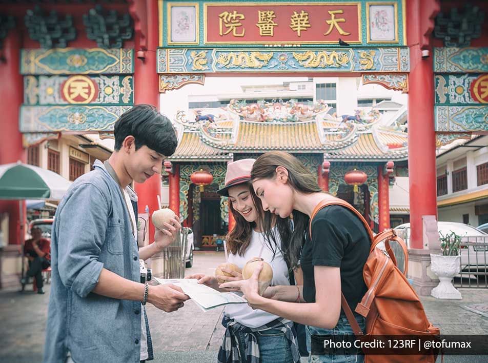 Group of young travelers reading a map outside a Chinese temple - Lexis Port Dickson