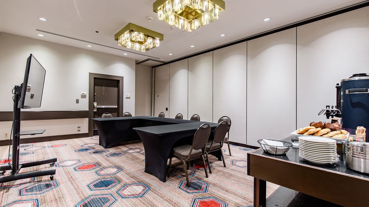 Meeting room with chairs, tables, TV, and refreshments