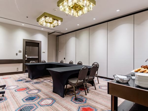 Meeting venue with tables, chairs, TV, and refreshments