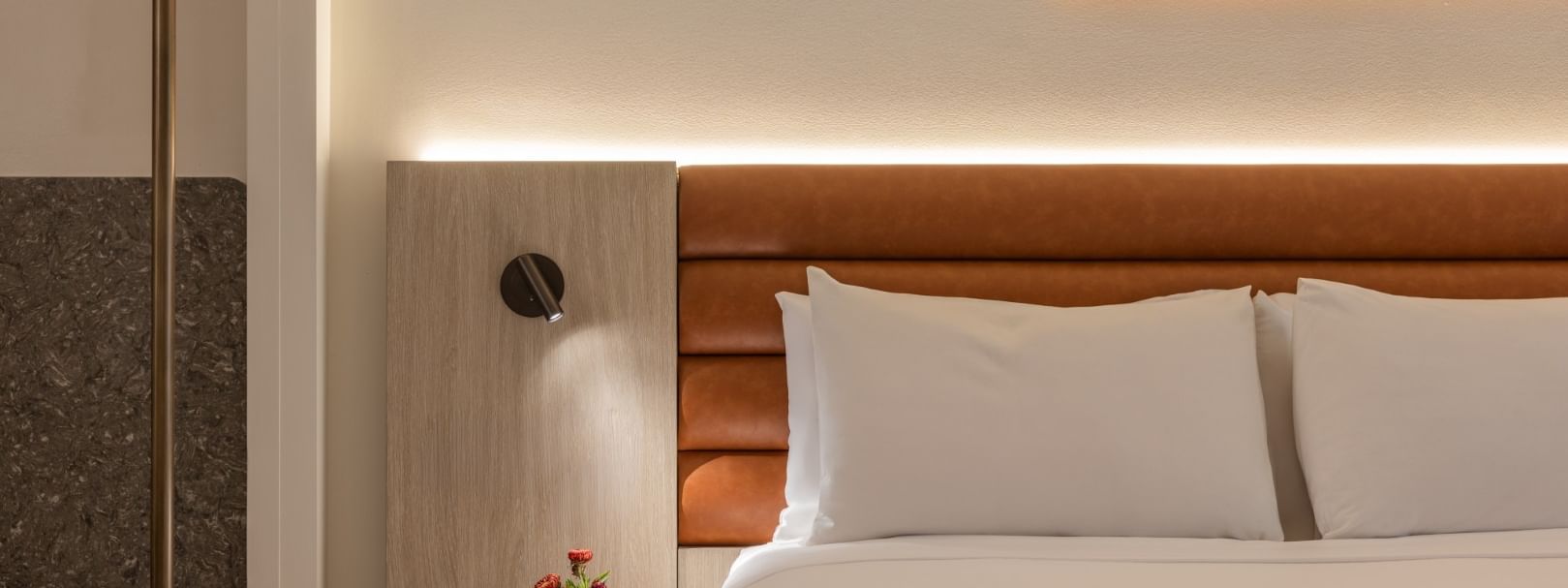 Modern deluxe room with white bedding, wooden headboard, ambient lighting, and tropical artwork at Novotel Sunshine Coast.