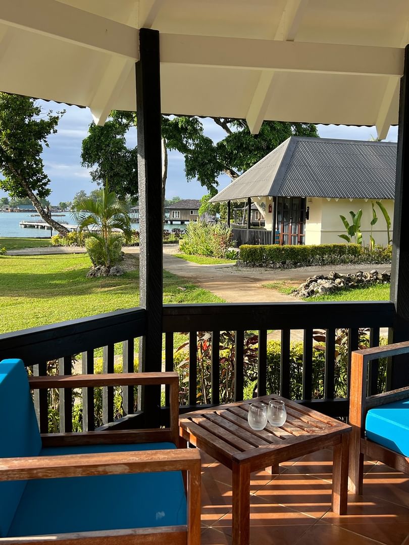 View of blue cushioned lounge chairs on porch of Garden Bungalow at Warwick Le Lagon - Vanuatu in Efate.