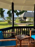 View of blue cushioned lounge chairs on porch of Garden Bungalow at Warwick Le Lagon - Vanuatu in Efate.