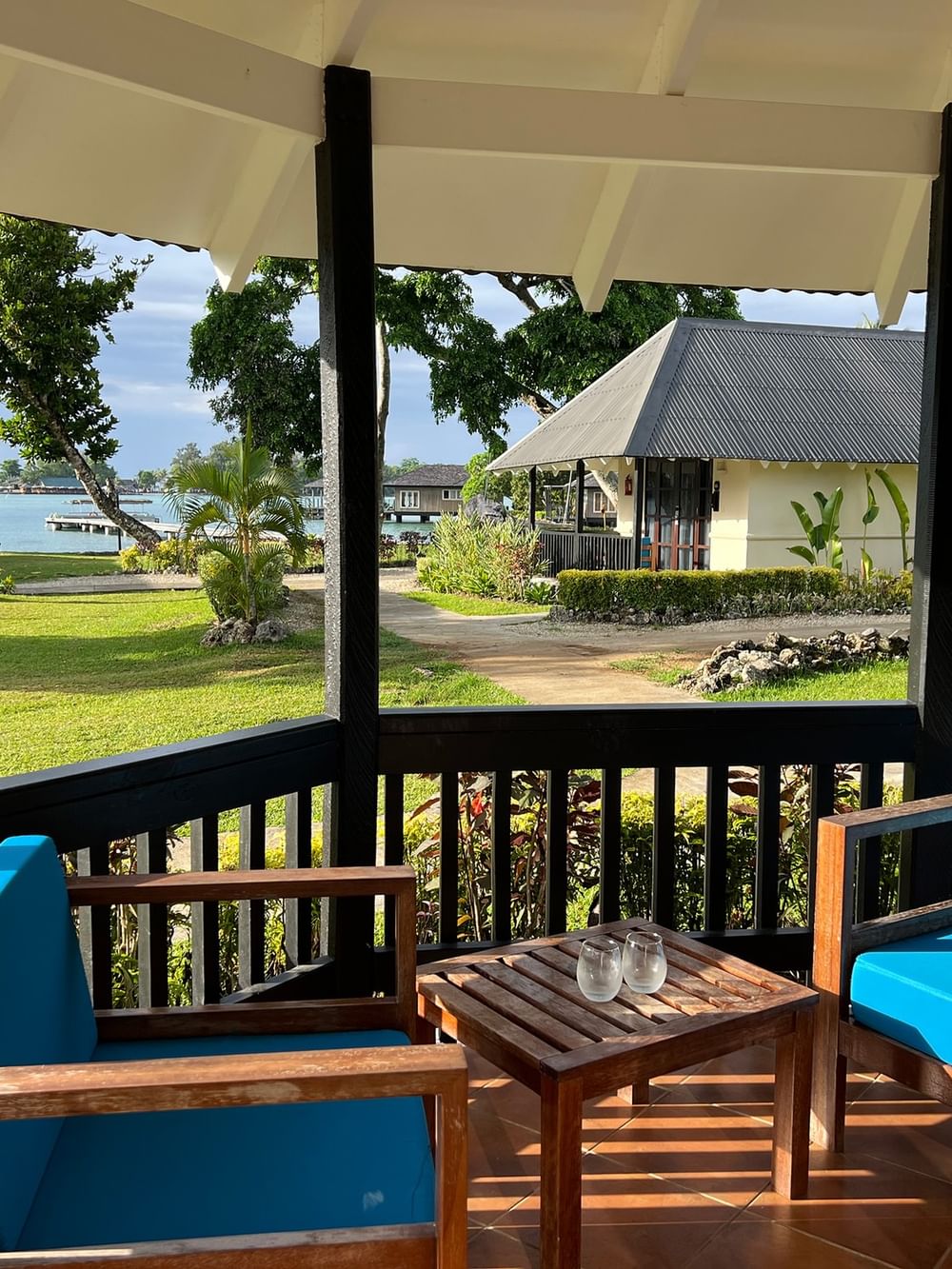 View of blue cushioned lounge chairs on porch of Garden Bungalow at Warwick Le Lagon - Vanuatu in Efate.