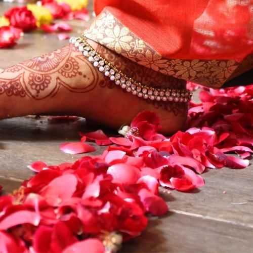 Bride taking a step also known as the sacred saptapadi, a popular Indian wedding tradition