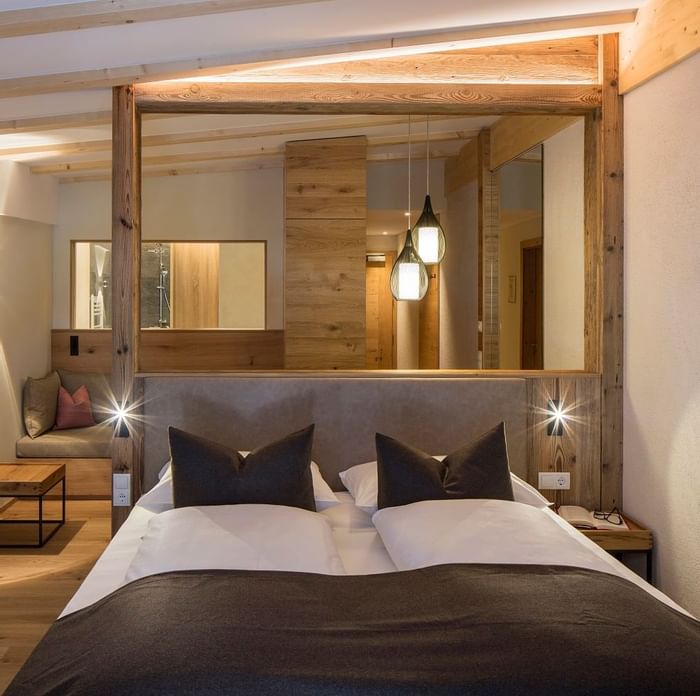 Large bed & lounge area in a room at Falkensteiner Hotels