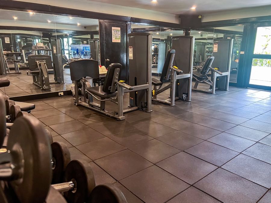 Fitness center with weight machines and dumbbells by large mirrors at TokaToka Resort Nadi Fiji