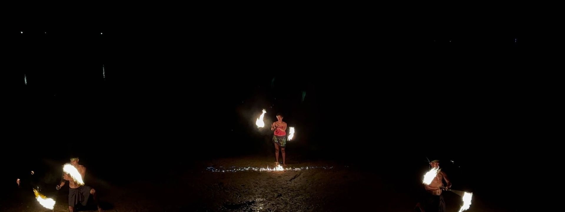 Performers engaging in a fire dance show in the dark at The Naviti Resort in Korolevu