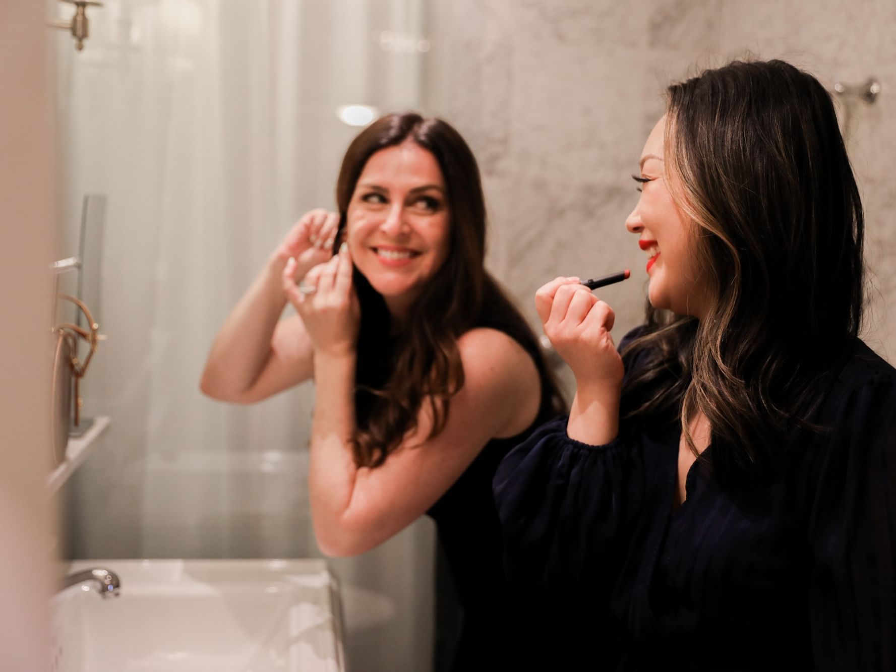 Close-up of two ladies getting ready for a party at Eliot Hotel