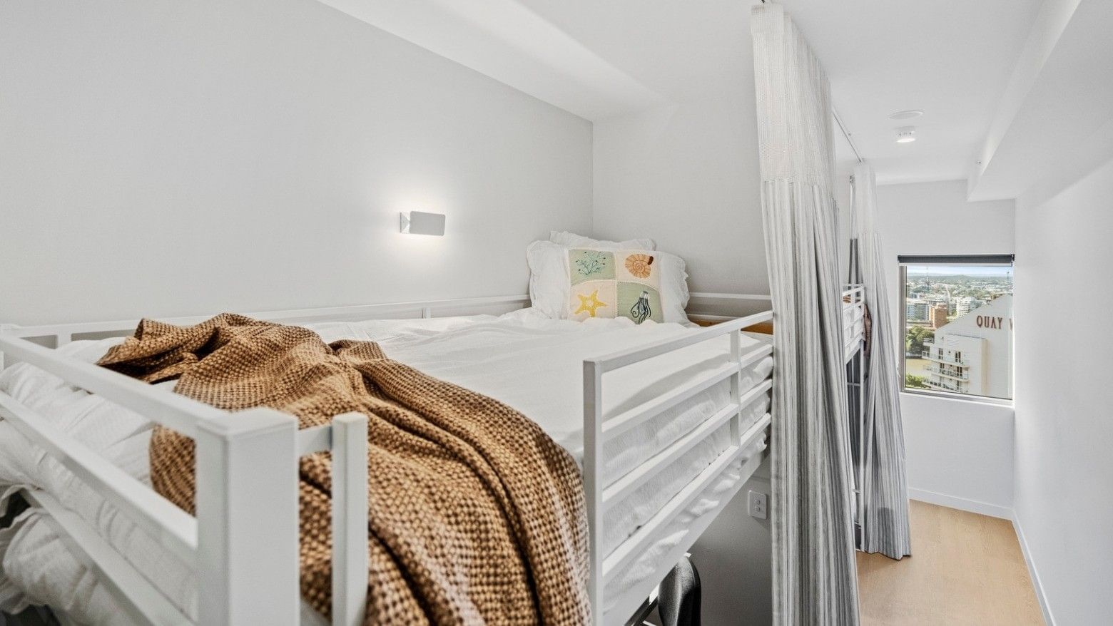 White bunk bed with curtains and cozy bedding in a clean room at UniLodge Brisbane City.