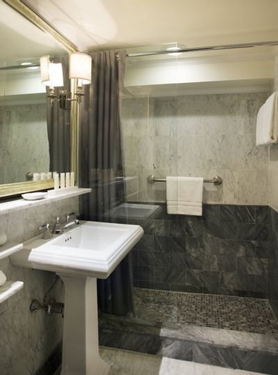Bathroom vanity & walk-in shower in a room at The Eliot Hotel