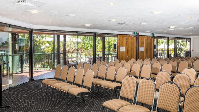 Theatre style Lakes Room with large glass doors leading to patio with greenery outside at Mercure Hotel Townsville