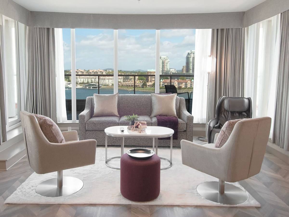 Hotel guestroom with wrap-around balcony, massage chair, and living area