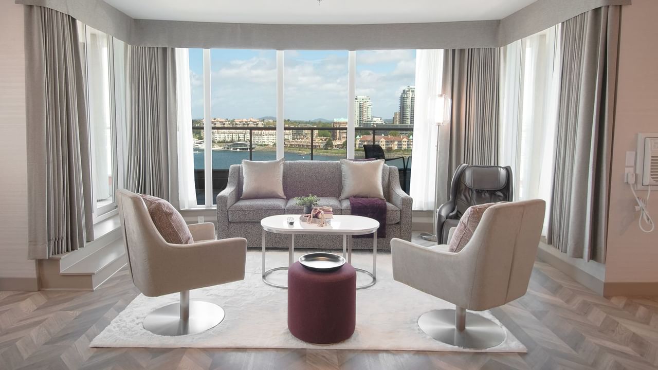 Hotel guestroom with wrap-around balcony, massage chair, and living area