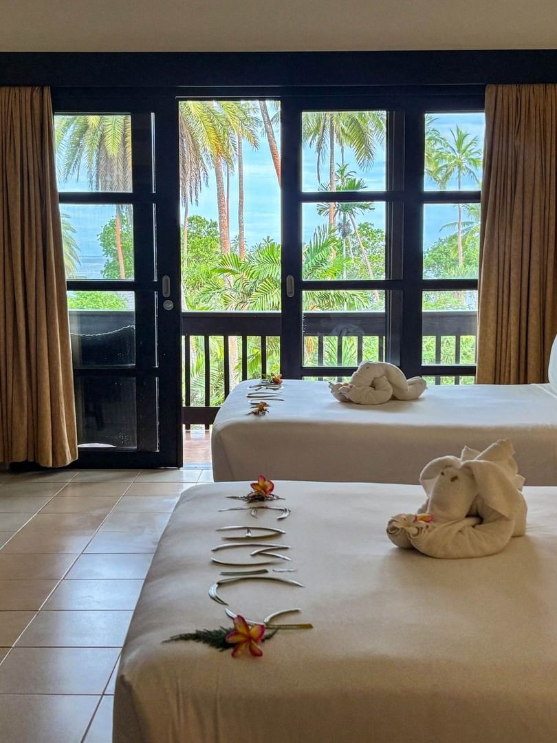 Two beds with ocean view and tropical decor in an Ocean View Room at The Naviti Resort, Korolevu.