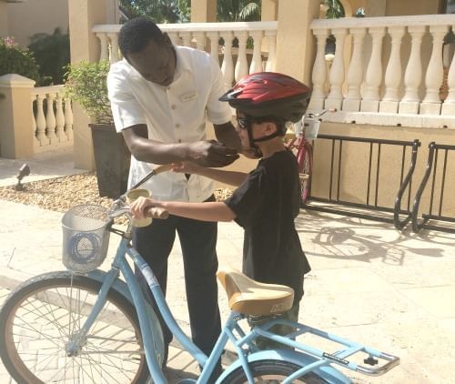 A child holding a bicycle near The Somerset On Grace Bay
