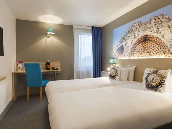 Bedroom with twin beds & a work desk at Hôtel de l'Europe