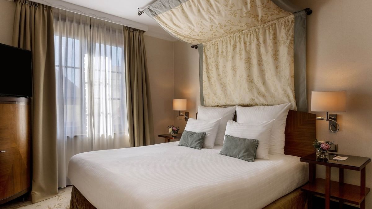Draped bed between the side tables near the window in Premium Room at Warwick Grand Place Brussels