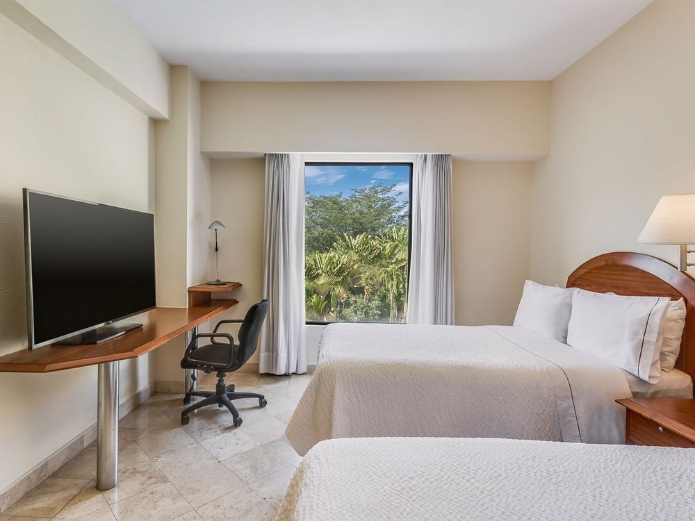 TV & work desk facing double beds with outside view in Superior Room, Double at Fiesta Inn