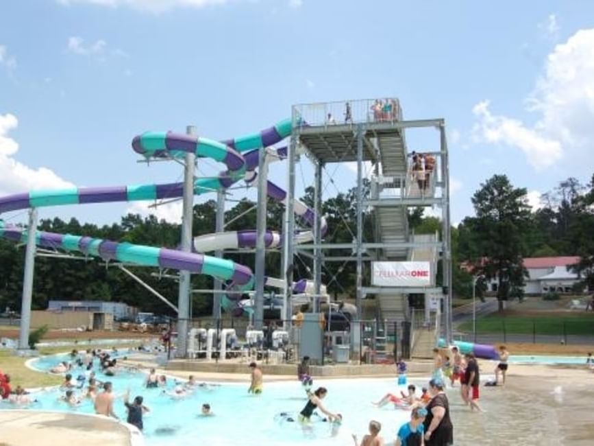 groups of people playing in a pool and water slide