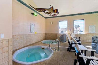 Indoor cozy hot tubs with loungers at Boothill Inn & Suites