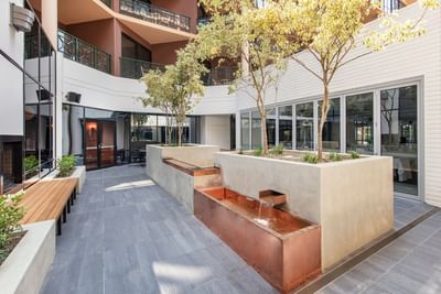 Outdoor water feature & wooden bench at Amora Hotel Melbourne