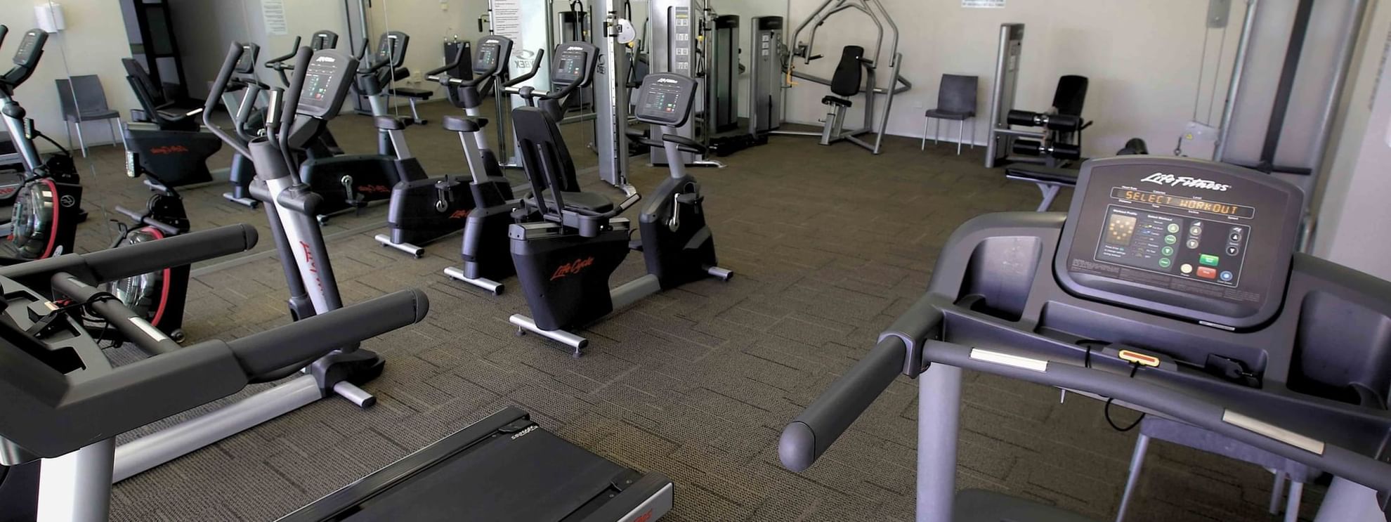 Gym interior with various exercise machines and TV at Mercure Kooindah Waters