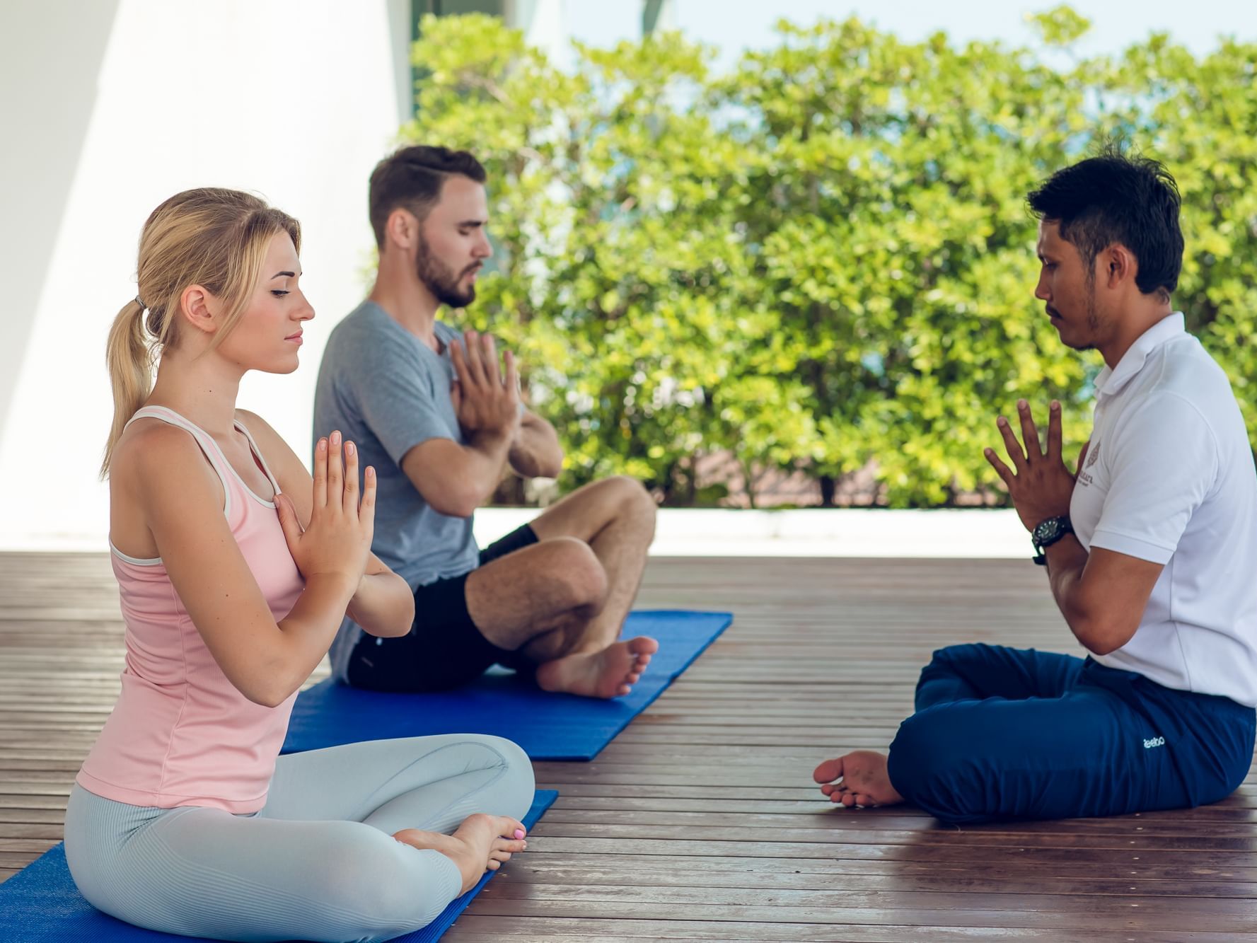 Three people meditating at Amatara Wellness Resort Phuket