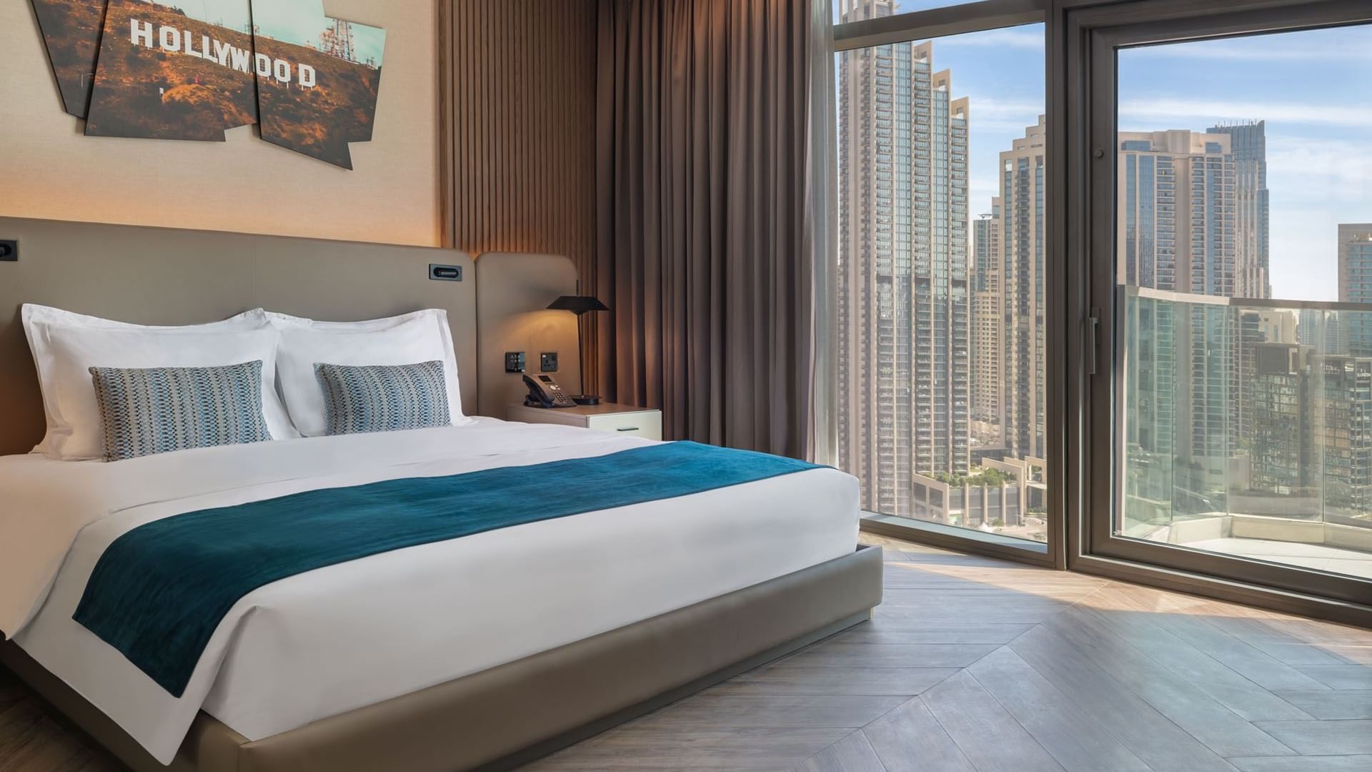 Comfy bed with nightstand by large window and wooden floors  in Premiere Suite at Paramount Hotel Midtown