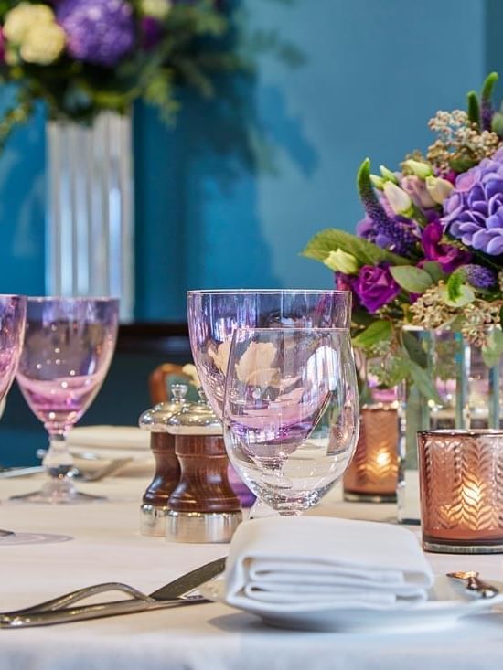 Floral centerpiece with candles on a table in Eaton Suite at The Capital Hotel, Apartments and Townhouse