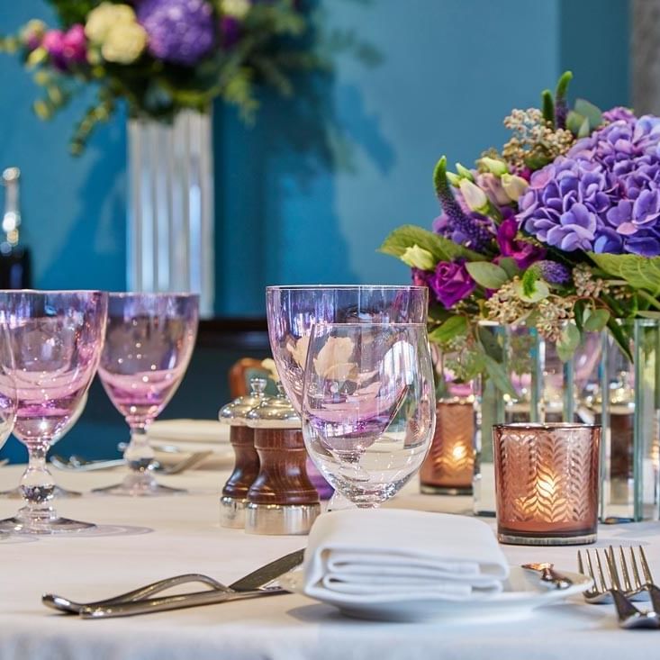 Floral centerpiece with candles on a table in Eaton Suite at The Capital Hotel, Apartments and Townhouse