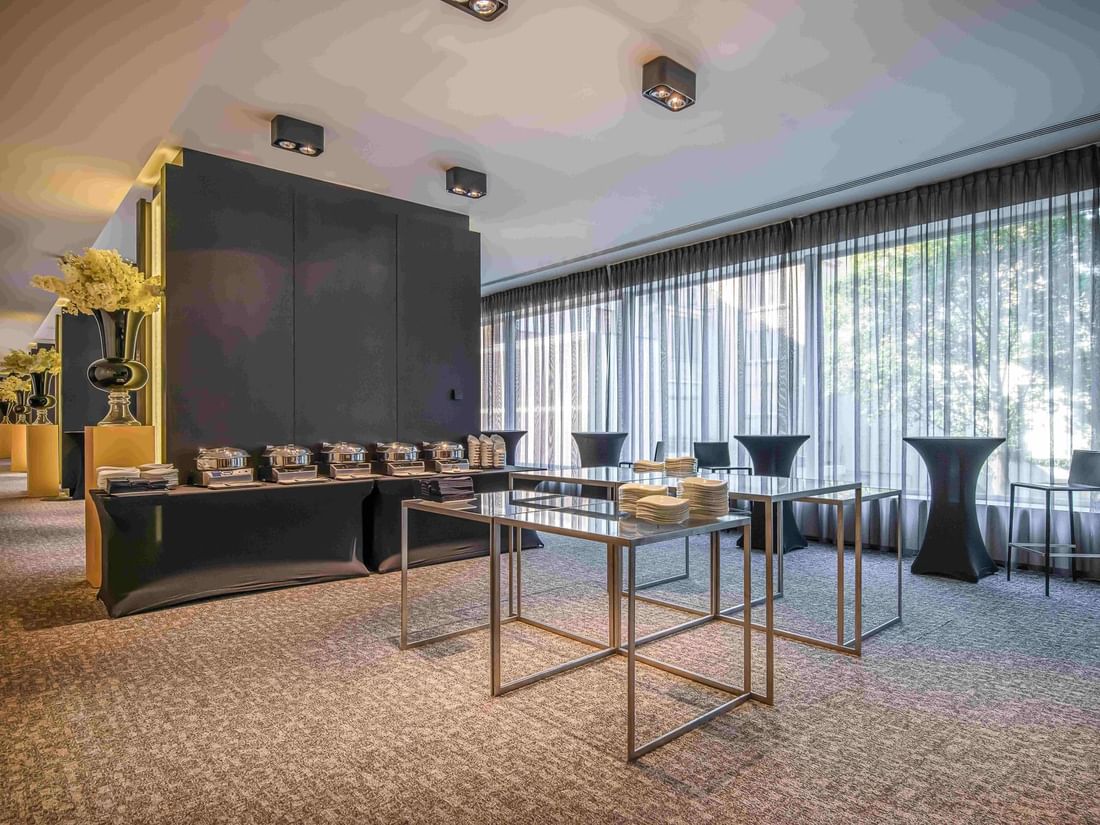Park Ballroom with tables set up for a catered function, large windows, and elegant decor at The Hotel Brussels