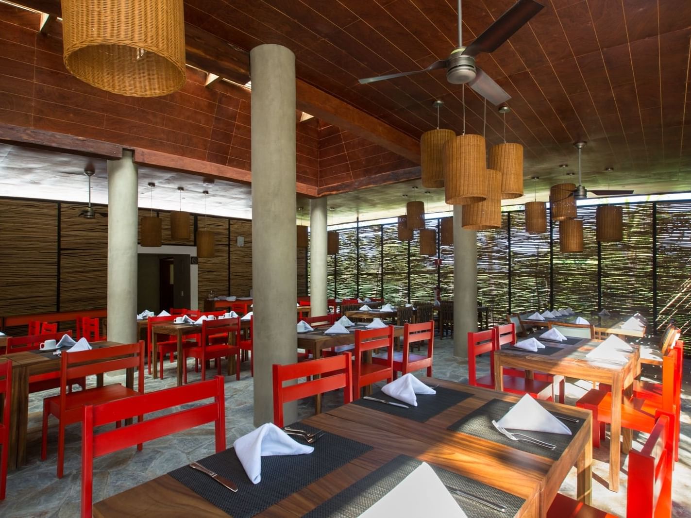 restaurant dining room with wooden tables and red chairs