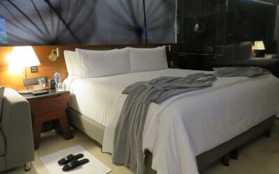 Bata y pantuflas junto a la cama en Live Aqua Beach Resort Cancún