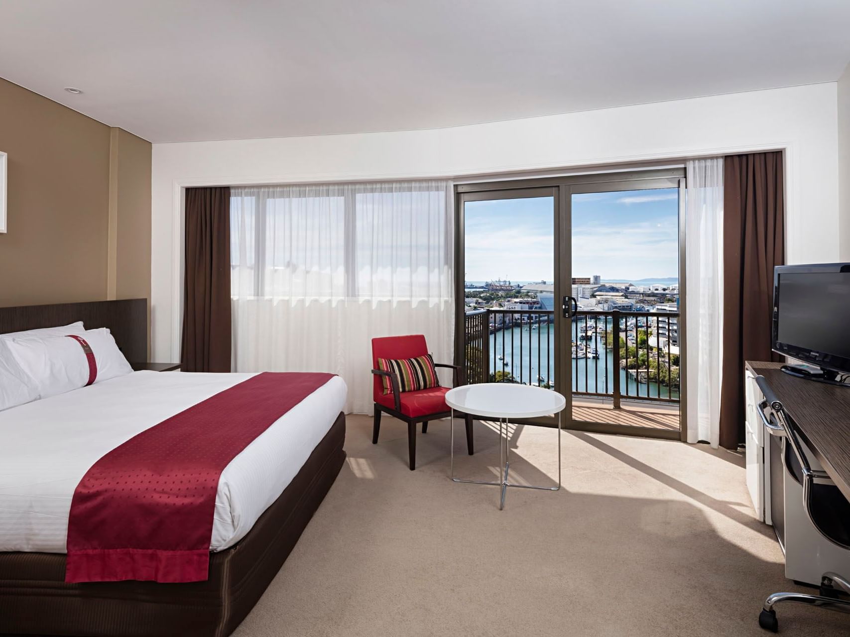 King-size bed, TV & balcony view in Standard King room at Hotel Grand Chancellor Townsville