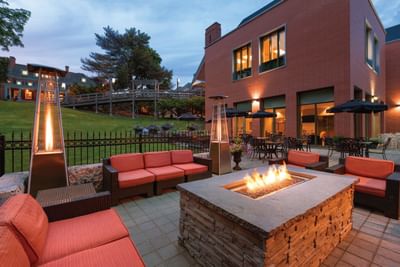 Stone fire pit & red lounge chairs in Asher\'s Lounge & Patio at Spencer Hotel, one of the best restaurants in London Ontario