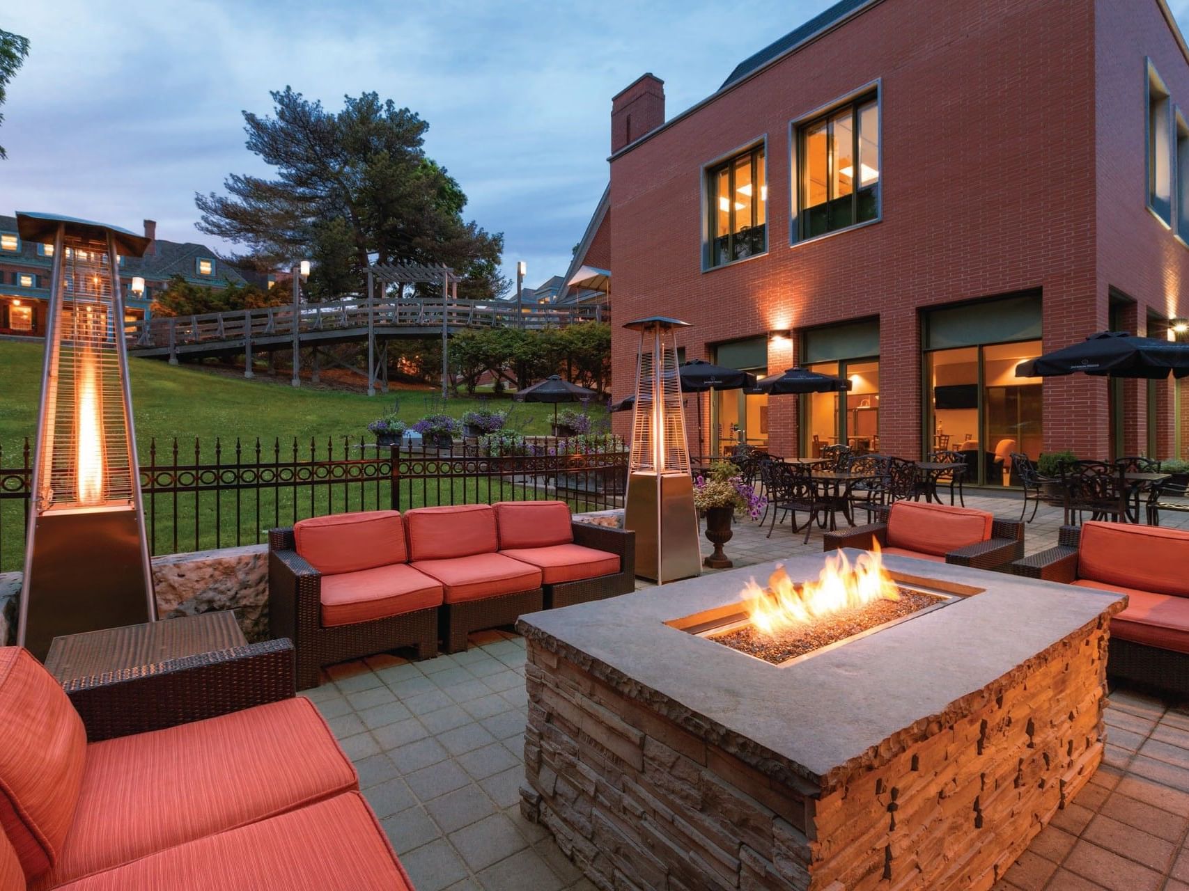 Stone fire pit & red lounge chairs in Asher\'s Lounge & Patio at Spencer Hotel, one of the best restaurants in London Ontario