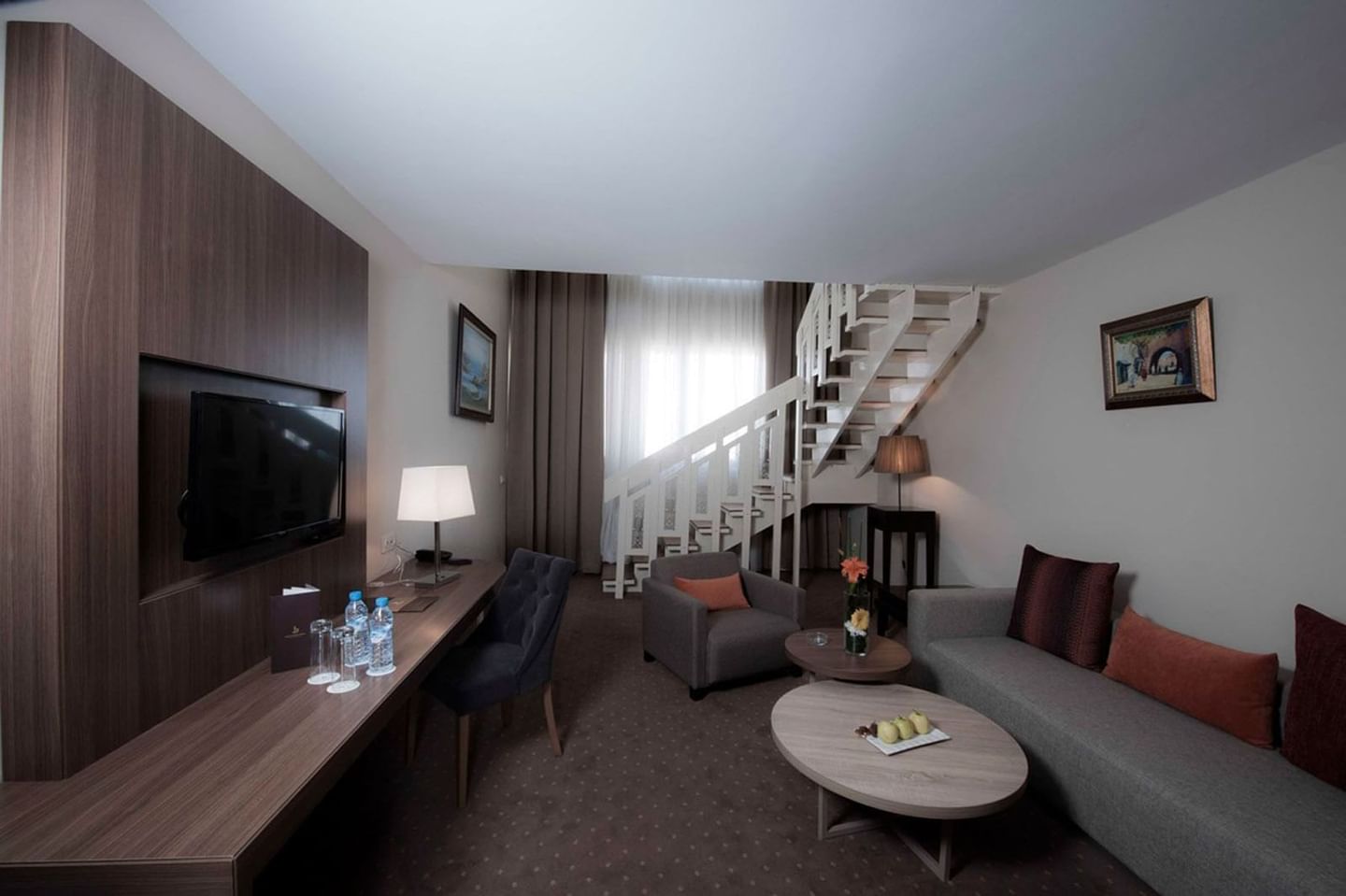 Intérieur élégant d'une suite avec salon et escalier menant à l'étage chez Kenzi Basma