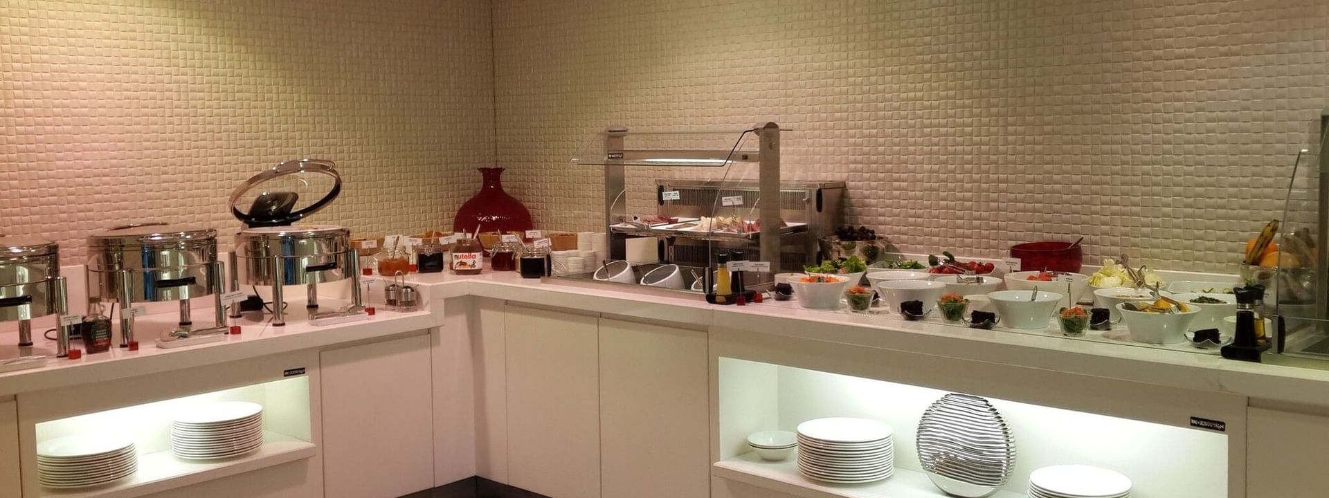 Breakfast buffet by a white counter surrounding fresh fruit and salad bowls in Breakfast & In-Room Dining at Warwick Ankara