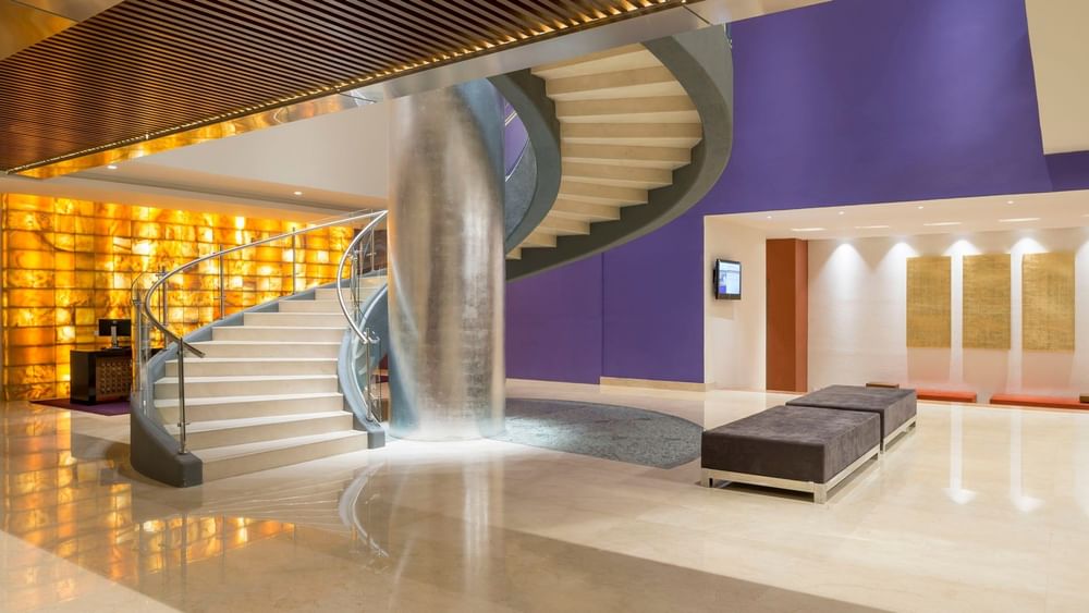 Ground view of the spiral stairs showing a sleek design and purple accents at Camino Real Pedregal Mexico