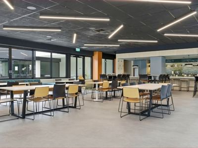 Modern dining area with tables, chairs, and a bar counter at Mayoral Drive Student Accommodation.