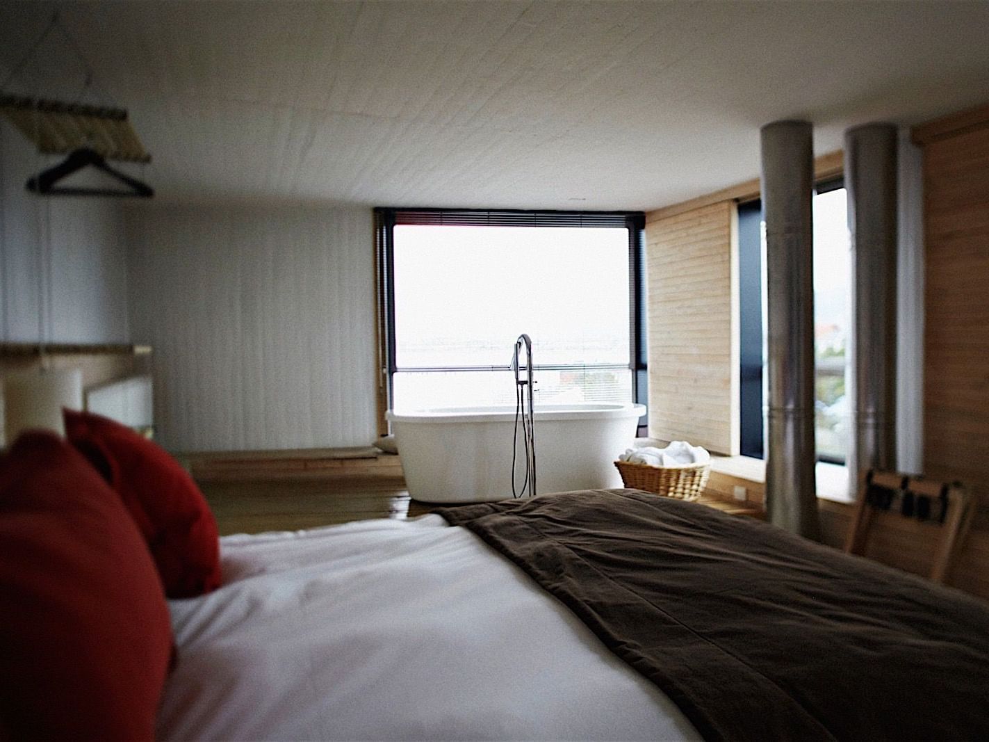 Suíte na Patagônia com cama grande e banheira junto à janela no NOI Indigo Patagonia