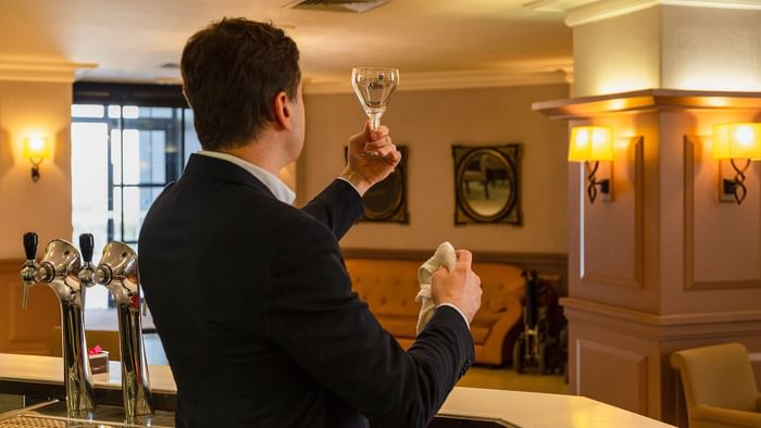 Bartender holding a glass in the bar at Hotel Astoria Vatican