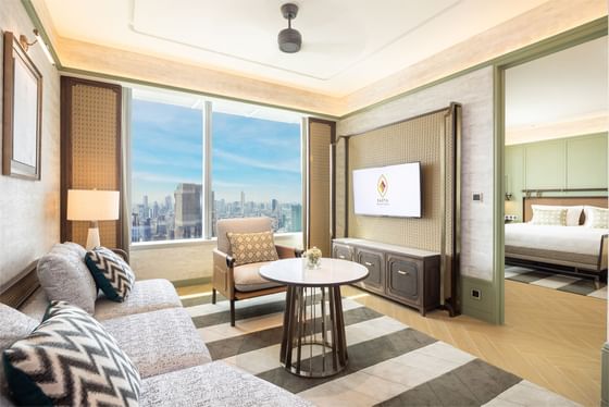Comfy sofa, TV & city view in one bedroom suite at Eastin Hotels