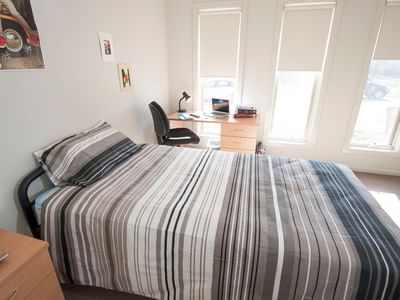 Neat room with bed, desk, and window at La Trobe University Regional Housing – Shepparton.