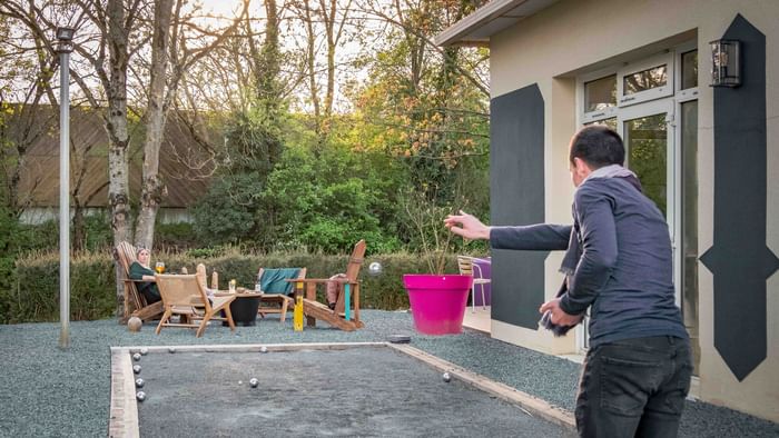 A man playing outdoor game with balls at The Originals Hotels