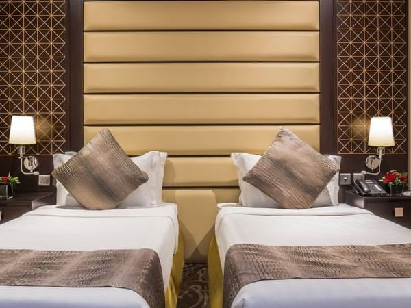 Standard King / Twin Bed features Two beds by nightstands with lamps at Naviti by Warwick Al Khobar