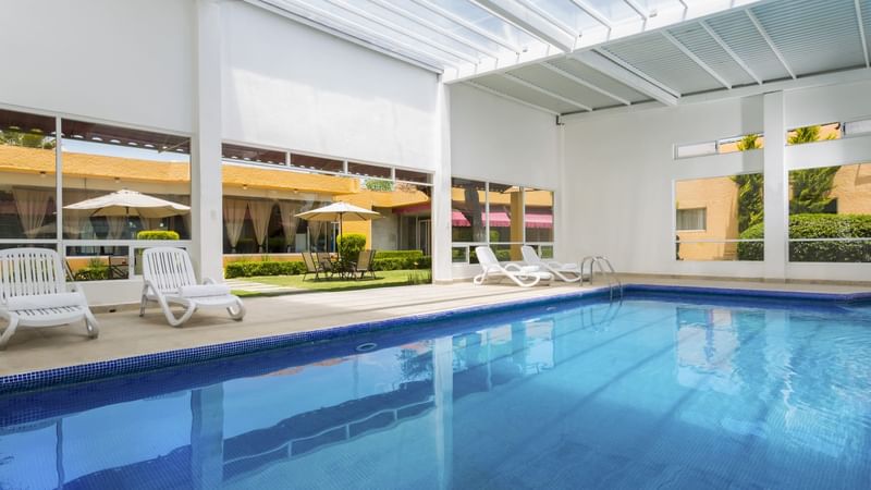 Indoor pool area with sunbeds at Gamma Pachuca
