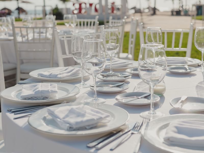 Elegantly set table with white linens and glassware at Fiesta Americana Riviera Nayarit Resort & Spa.