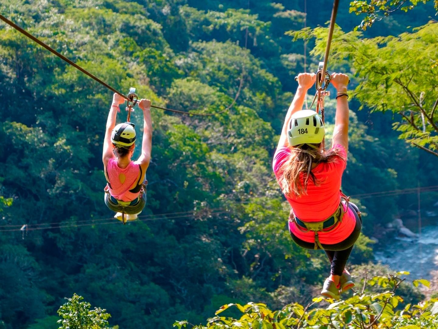 2 People enjoying zipline in Canopy River Park near Plaza Pelicanos Club Beach Resort